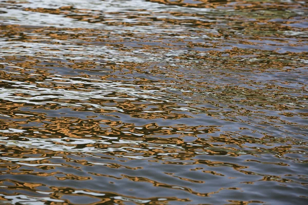 Orange blue white reflection on surface water with waves — Stock Photo, Image