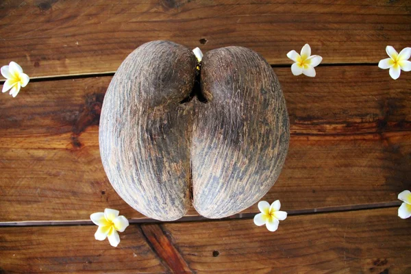 Seychelles double with flowers decorated on an old wooden table