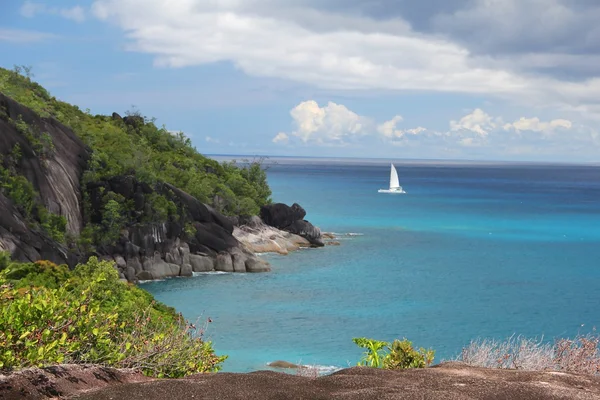 Rocky landscape in the Seychelles with sailing boat on the sea Royalty Free Stock Photos