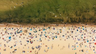 Güneş banyosu yapan insanlarla sahilin havadan görünüşü
