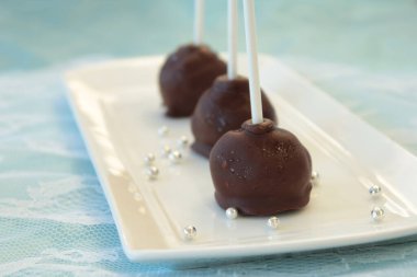 Çikolata sosu ve çikolata parçacıklarıyla süslenmiş kek patlağı tatlısı.