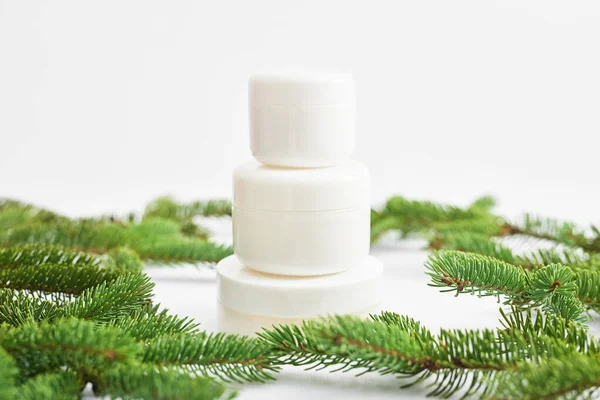 크리스마스 화장품 플랫은 제품과 전나무 가지를 배경으로 조화를 이루었다 — 스톡 사진
