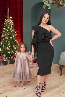 Noel ailesi. Mutlu noel ağacı geçmişi. Kadın anne ve çocuk yeni yılı kutluyor. Xmas tebrik kartı. Kış tatilleri ve tatiller