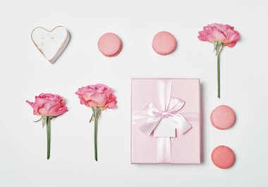 Makarna tatlısı ve bir şişe şampanya. Romantik kahvaltı ve akşam yemeği Sevgililer Günü tebrik kartı. Çiçekler ve hediye kutuları beyaz arka planda. Mutlu yıllar ve anneler günü şablonu