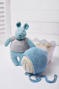 Dikiş ve örgü. Hobiler ve yaratıcılık. Çocuklar için örgü. Örgü oyuncaklar, tavşan ve şapka. El yapımı oyuncak tavşan. Bebek şapkası. İplik, iplik ve toplar.