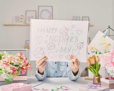 Anneler Günü tebrik kartı. Çocuk kartpostalı. Anneme bir hediye. Çocuk resim çiziyor..