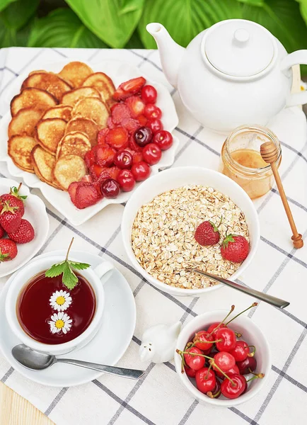 外面吃早餐草莓 迷你煎饼燕麦片 蜂蜜在桌子上 夏天野餐 早上好 — 图库照片
