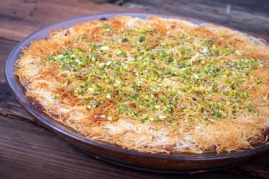 Kanafe Arap peynirli kek, üstüne yeşil badem konmuş, yakın plan.