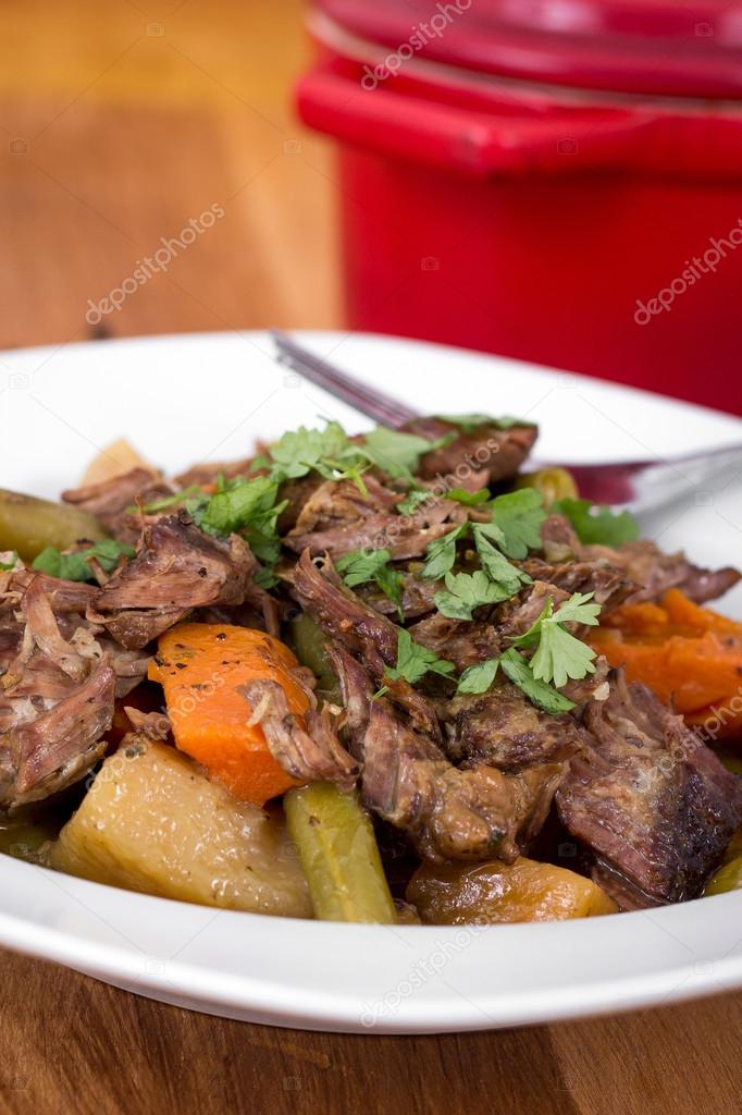 Braised beef pot roast stew with vegetables on table