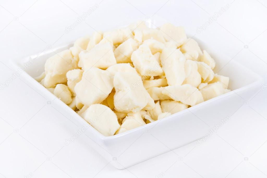 white dairy cheese curd in a bowl over white background