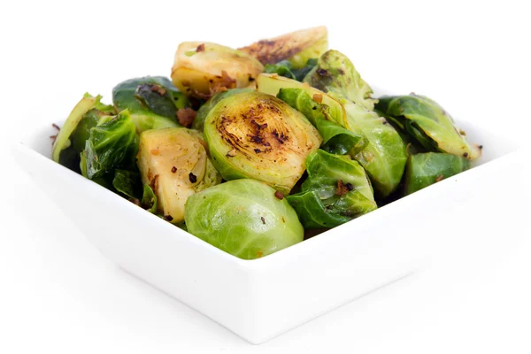 Roasted brussels sprouts with bacon over white background