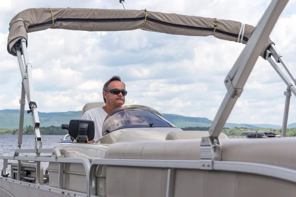 Homens maduros dirigindo um barco de pontão em um lago — Fotografia de Stock