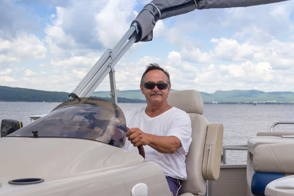 成熟した男性の湖畔にポンツーン ボートの運転 — ストック写真