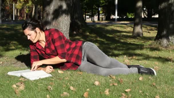 Жінки вивчають книгу в парку — стокове відео