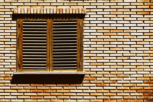 Janela de casa simples na parede de tijolo vermelho — Fotografia de Stock