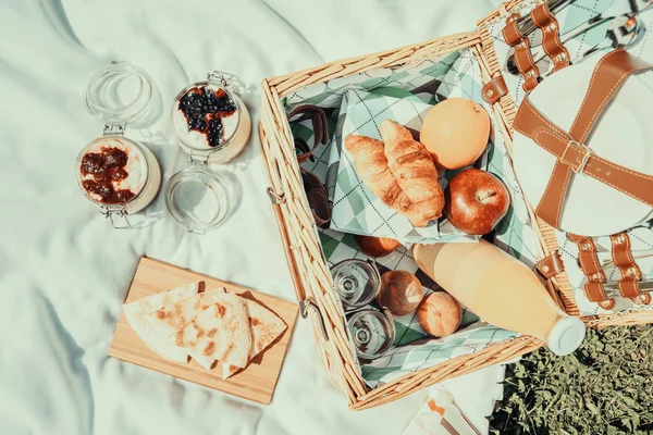 Cesto da picnic con frutta, succo d'arancia, croissant, quesadilla e nessuna torta di mirtillo e marmellata di fragole — Foto Stock