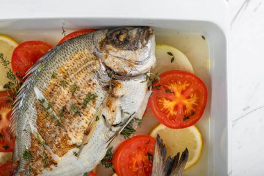 Fırında pişirilmiş domatesli ve kekikli deniz çamı.