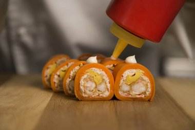 Suşi ustası Japonlara servis yapıyor. Tahta tahtada mayonezli pirinç rulosu yok. Şef tempura karidesli yemek hazırlıyor. Sushi Roll servis ediliyor. Profesyonel aşçılık süreci. natürmort 