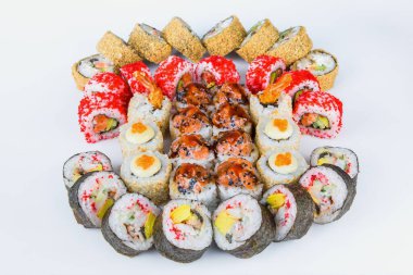 Büyük bir suşi dilimi, deniz ürünleri ve çiğ balık. Futomaki ve tempura suşi ruloları. Arka planda izole edilmiş farklı deniz ürünleri içeren doğu yemekleri dilimlerinin büyük çeşitliliği. 