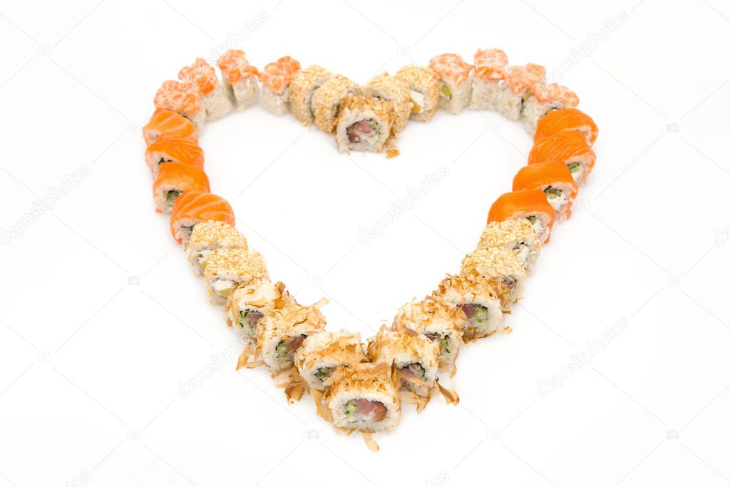 Close-up top view of Asian  sushi rolls set isolated on on white background. Sushi served in food heart shape. Copy space , food isolation for Japanese meal menu