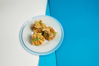 İçinde tavuk eti olan Rus başlangıç yemeği blini 'nin en iyi görüntüsü. Geleneksel taze soğan soğanlı krep aperatifi. Mavi soyut arka planda enfes bir yeni yıl yemeği