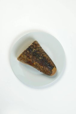 Doldurulmuş sazan balığı. Yahudi geleneksel gefilte balığı kesimi beyaz arka planda izole edilmiş tabakta servis edilir. Balık derisinde sebzeli kıymalı balık filetosu fırında. Tabak beyazda izole