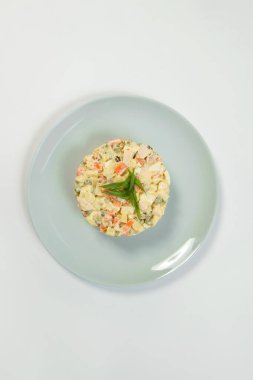 Geleneksel Rus Olivier salatası manzarası. Mayonez soslu haşlanmış sebze tabağı. Yılbaşı soğuk yemeği gri tabakta servis edilir. Nesne arka planda izole edildi.