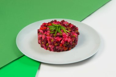 Rus sirkeli pancar salatasının yan görüntüsü. Renkli yeşil arka planda taze soğan soğanları ile servis edilen yağ ve sirkeli geleneksel salata. Haşlanmış sebze salatası.