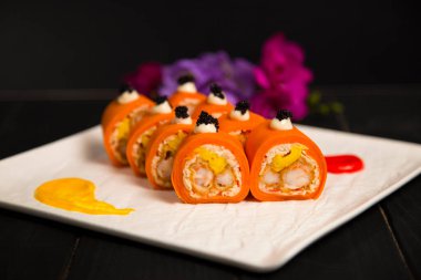 Sağlıklı Japon yemeğinin yanında pirinç suşi rulosu yok. Tempura siyah kaplan karidesi (karides) soslu havuç ve siyah havyar ile servis ediliyor. Çiçekler, boya fırça darbeleri beyaz tabakta