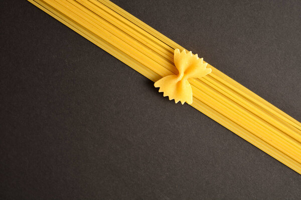 На темном фоне выложить фарфоровую пасту из спагетти. Пищевая имитация ленты и лука