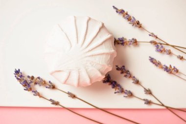 Beyaz tabakta, pastel pembe arka planda kuru lavanta bitkileriyle servis edilen bir tatlı. Rus marşmelovu yumurta beyazı, meyve ezmesi ve organik elma pektin. Seçici odak