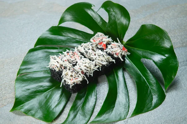 Seitenansicht Der Japanischen Schwarzen Reisrolle Mit Geschnittenen Schneekrabbenfleischstäbchen Auf Tropischem — Stockfoto