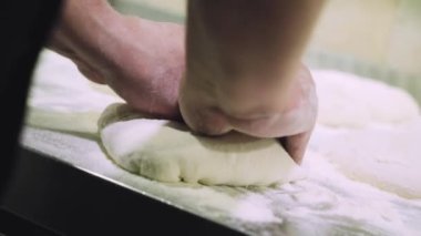 Şef pizza hamuru yapıyor. Eller ve hamur. Pizza hamuru pişiriyorum. Şef pizza için hamur hazırlıyor..