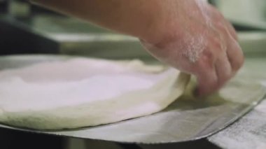 Şef pizza hamuru yapıyor. Eller ve hamur. Pizza hamuru pişiriyorum. Şef pizza için hamur hazırlıyor..