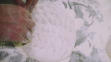 Şef pizza hamuru yapıyor. Eller ve hamur. Pizza hamuru pişiriyorum. Şef pizza için hamur hazırlıyor..