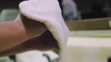 Şef pizza hamuru yapıyor. Eller ve hamur. Pizza hamuru pişiriyorum. Şef pizza için hamur hazırlıyor..