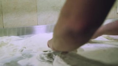 Şef pizza hamuru yapıyor. Eller ve hamur. Pizza hamuru pişiriyorum. Şef pizza için hamur hazırlıyor..
