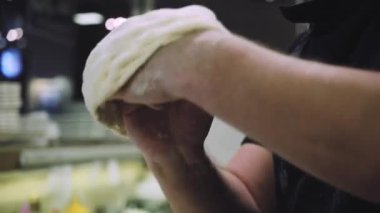Şef pizza hamuru yapıyor. Eller ve hamur. Pizza hamuru pişiriyorum. Şef pizza için hamur hazırlıyor..