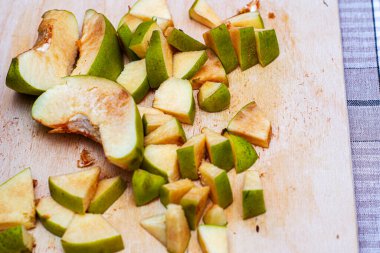 Ayva, reçel yapmak için dilimlenmiş, tahta kesme tahtasının üzerinde yatıyor.