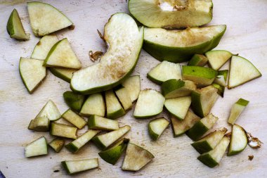 Ayva, reçel yapmak için dilimlenmiş, tahta kesme tahtasının üzerinde yatıyor.