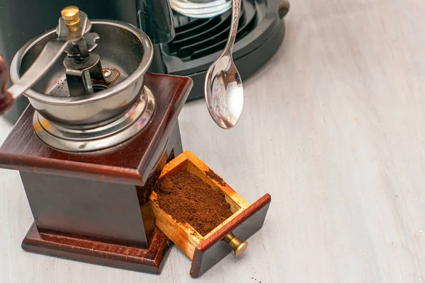 a person makes coffee in a coffee machine picks up ground coffee with a spoon from a coffee grinder drawer. High quality photo