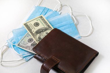 Coronavirus konsepti ve maske ticareti yüz dolarlık banknotlarla dolu bir cüzdan. Yüksek kalite fotoğraf