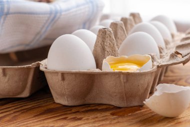 İçinde yumurta sarısı olan kırık yumurta bütün yumurtalarla birlikte stantta yatıyor. Yüksek kalite fotoğraf