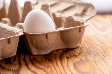 Masada bir beyaz tavuk yumurtası var. Yüksek kalite fotoğraf