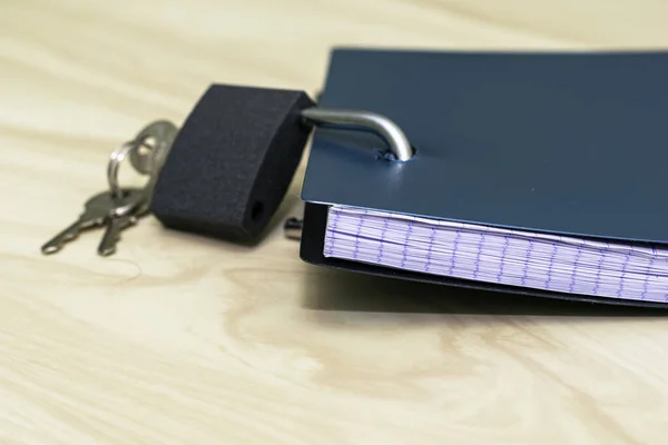 the concept of information protection an open lock with keys hangs on the notebook for notes. High quality photo