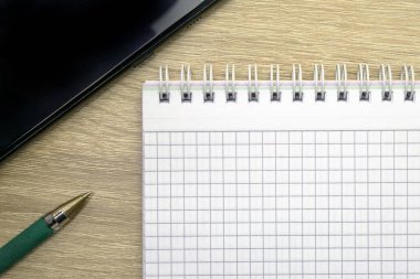 Fotokopi masasında bir not defteri, bir dolmakalem ve bir akıllı telefon var. Yüksek kalite fotoğraf