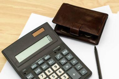 Hesap makinesi cüzdanı ve dolmakalem beyaz kağıt tabakalarının üzerinde. Yüksek kalite fotoğraf