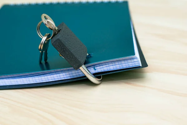 the concept of information protection a closed lock with keys hangs on the notebook for notes