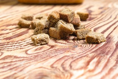 Arka plandaki ahşap masada çavdar krakerleri bulanık bir somun ekmek. Yüksek kalite fotoğraf