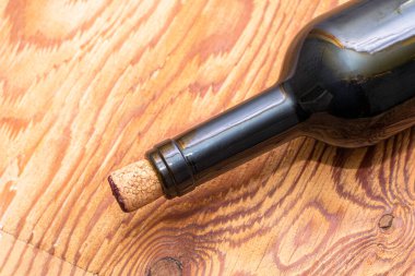 Şarap şişesinden çıkan bir mantar, ahşap bir masanın üzerinde duruyor. Yüksek kalite fotoğraf